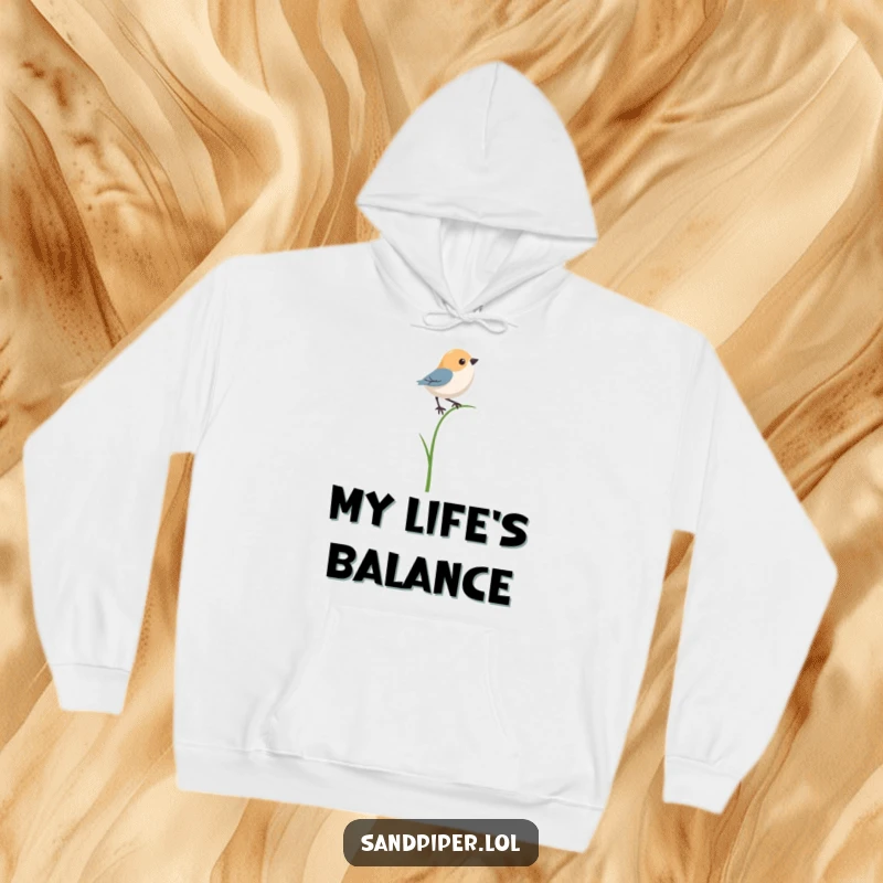 Funny hoodie illustrating a bird character humorously trying to maintain balance on a single, thin blade of grass.