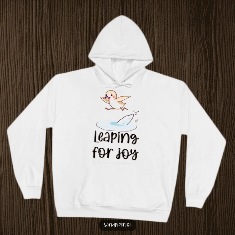 Funny Sandpiper Leap Hoodie: A sandpiper joyfully leaps over a small wave, depicted on a cozy hoodie for beach lovers.