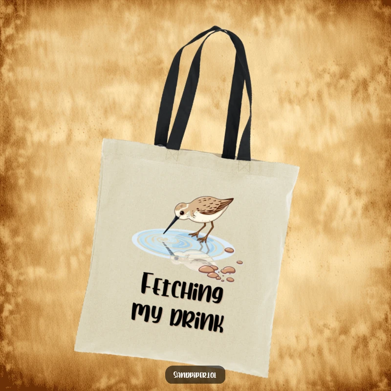 Durable tote bag featuring a sandpiper bird dipping its beak into a sparkling tidal pool, perfect for beach finds.